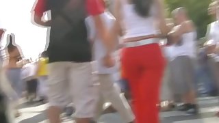 Sizzling brunette wearing bright red pants public street candid vid